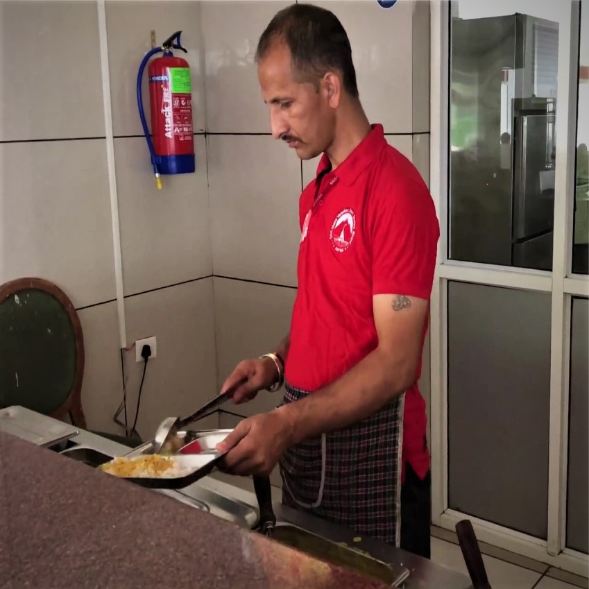 Person serving food inside Langar hall